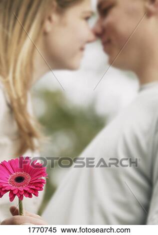 Stock Photography - Couple holding flower. Fotosearch