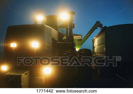 Stock Image - Farm machinery working at night. Fotosearch