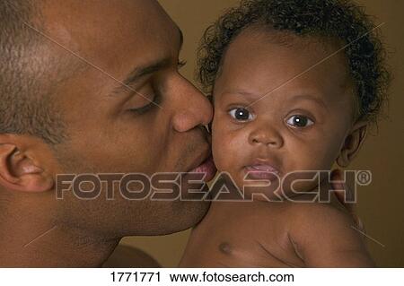 Stock Image - Father kissing baby. Fotosearch
