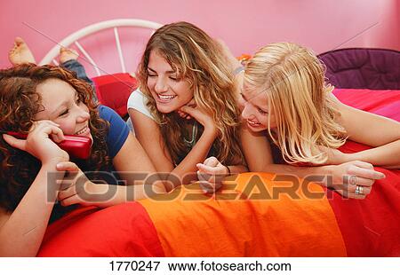 Girlfriends talking on phone View Large Photo Image Stock Photo - Girlfriends talking on phone. Fotosearch
