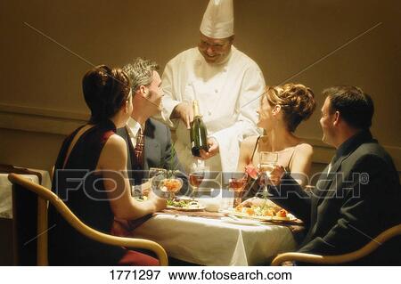 Stock Photo - Group having dinner in restaurant. Fotosearch