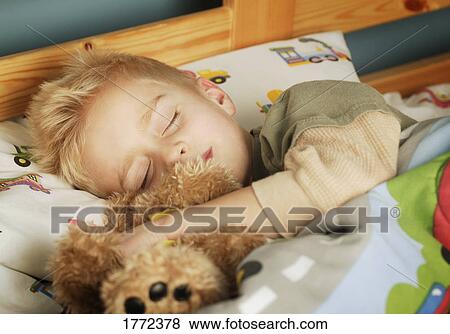 Stock Photo - Little boy fast asleep in bed. Fotosearch