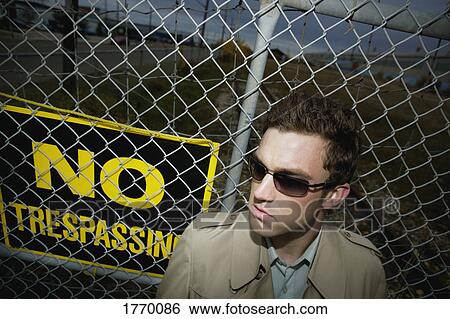 Man beside a no trespassing sign View Large Photo Image Stock Photograph - Man beside a no trespassing sign. Fotosearch