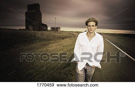 Stock Photo - Man walking along roadside. Fotosearch