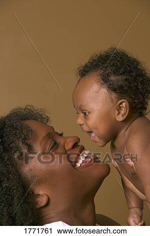 Stock Image - Mother holding baby to face. Fotosearch
