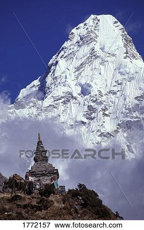 Stock Photo - Mountain peak in the clouds behind cultural monument. Fotosearch