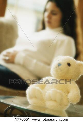 Stock Image - Pregnant woman with teddy bear. Fotosearch
