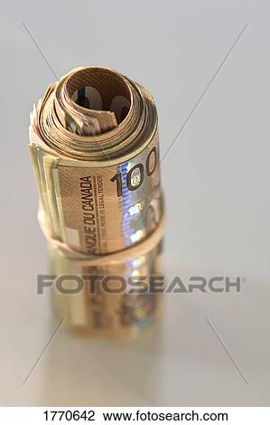 Stock Image - Roll of Canadian one hundred dollar bills. Fotosearch