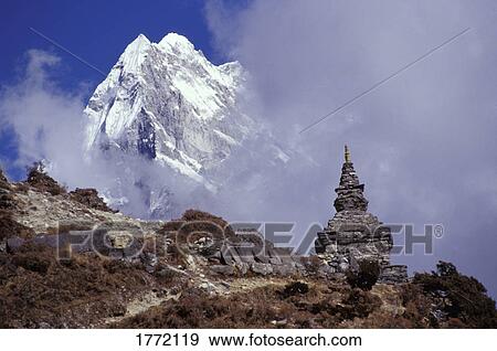 Stock Photo - Snow covered peak with cultural monument in forefront. Fotosearch