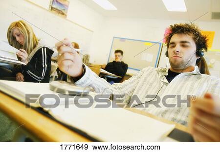 Student listening to music in class View Large Photo Image Stock Photo - Student listening to music in class. Fotosearch
