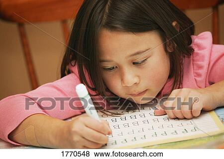 Stock Photo - Student practices alphabet. Fotosearch