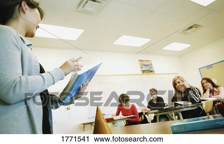 Stock Image - Teacher teaching in class. Fotosearch