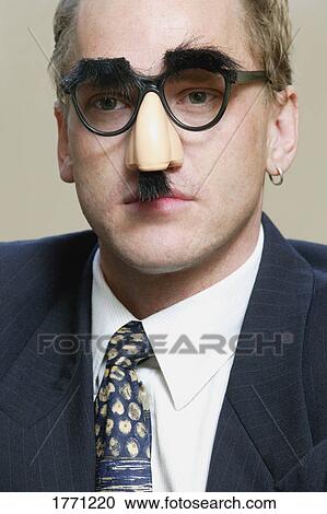 Thoughtful businessman wearing Groucho Marx mask View Large Photo Image Stock Image - Thoughtful businessman wearing Groucho Marx mask. Fotosearch
