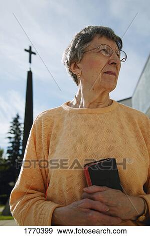 Stock Photo - Woman holding bible in hand. Fotosearch