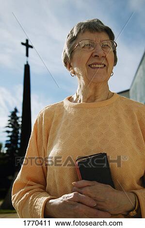 Stock Image - Woman holding bible. Fotosearch