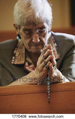 Woman praying with rosary beads View Large Photo Image Stock Photo - Woman praying with rosary beads. Fotosearch