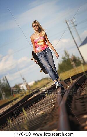 Woman walking on train tracks View Large Photo Image Stock Image - Woman walking on train tracks. Fotosearch