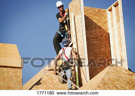 Stock Image - Workers building chimney. Fotosearch