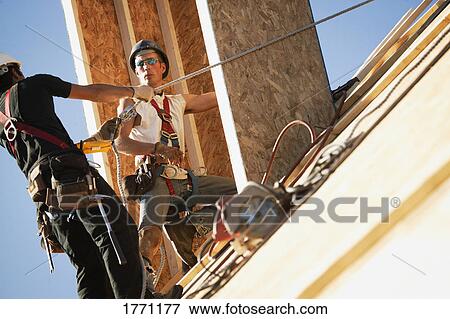 Stock Photo - Workers on roof. Fotosearch