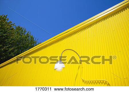 Yellow metal wall contrasting blue sky View Large Photo Image Stock Image - Yellow metal wall contrasting blue sky. Fotosearch