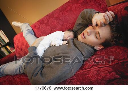 Stock Photograph - Young man asleep with new baby. Fotosearch