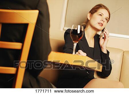 Stock Image - Young professional businesswoman in bar. Fotosearch