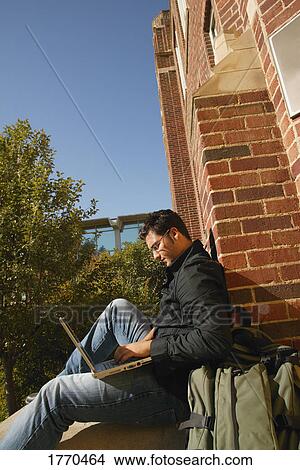 Picture - Youth working on laptop. Fotosearch
