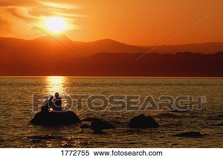 A couple admiring the sun set View Large Photo Image Stock Photography - A couple admiring the sun set. Fotosearch