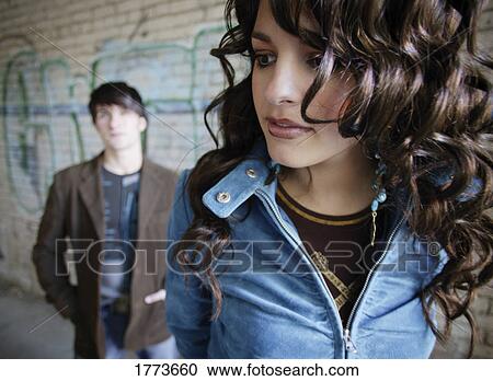 Stock Image - Attractive dark haired woman with man in background. Fotosearch
