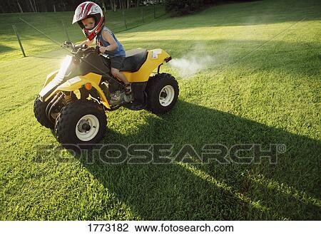 Boy riding child's quad bike View Large Photo Image Stock Image - Boy riding child's quad bike. Fotosearch