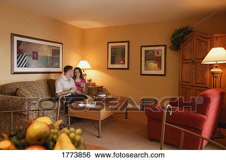 Couple relaxing in room View Large Photo Image Stock Photograph - Couple relaxing in room. Fotosearch