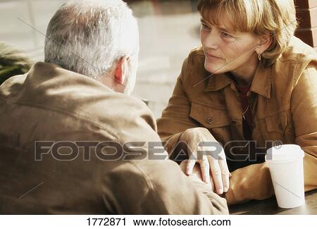 Couple sitting at table View Large Photo Image Stock Image - Couple sitting at table. Fotosearch