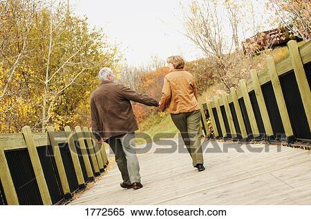 Couple walking across bridge View Large Photo Image Stock Photography - Couple walking across bridge. Fotosearch
