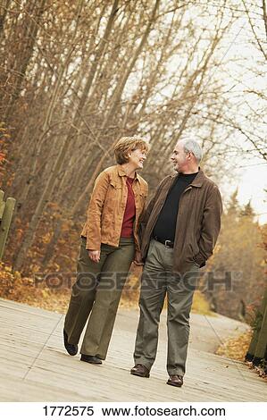 Couple walking hand in hand View Large Photo Image Stock Photography - Couple walking hand in hand. Fotosearch