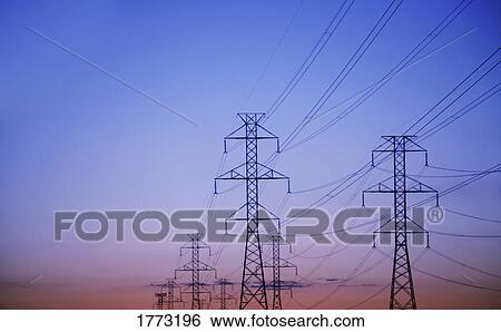 electricity pylons against a sunset backdrop View Large Photo Image Stock Photograph - electricity pylons against a sunset backdrop. Fotosearch