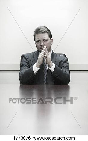 Stock Photograph - Executive sitting at boardroom table. Fotosearch