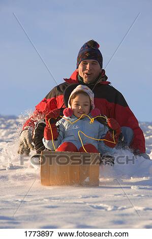 Father and daughter tobogganing View Large Photo Image Stock Photo - Father and daughter tobogganing. Fotosearch