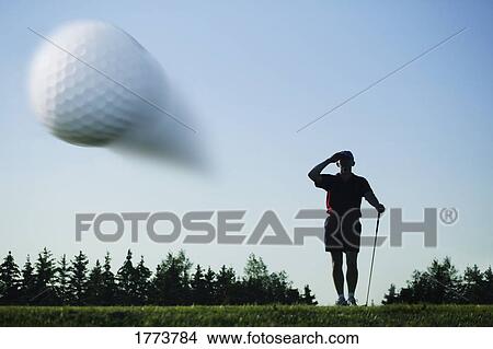 Picture - Golf ball in flight. Fotosearch