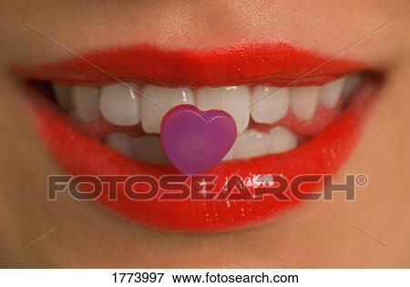 Stock Photo - Heart candy stuck on teeth. Fotosearch