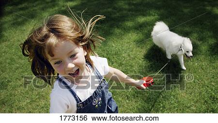 Little girl playing with her dog View Large Photo Image Stock Photograph - Little girl playing with her dog. Fotosearch