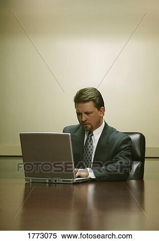 Male executive working on laptop View Large Photo Image Stock Photography - Male executive working on laptop. Fotosearch