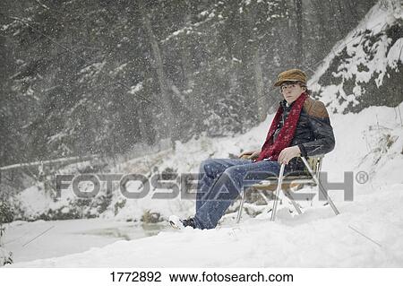Man sitting in chair as it snows View Large Photo Image Stock Image - Man sitting in chair as it snows. Fotosearch