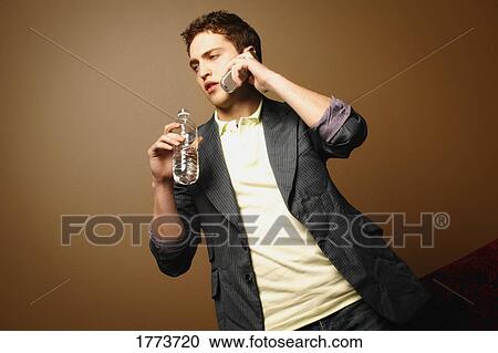 Stock Image - Man with water bottle and cell phone. Fotosearch