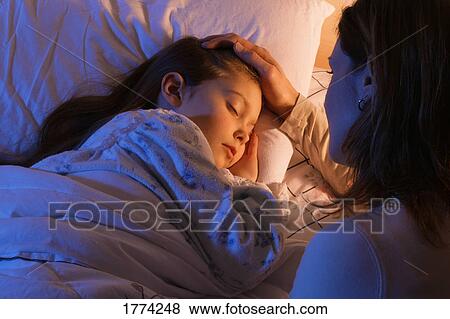 Stock Photo - Mother beside sleeping daughter. Fotosearch