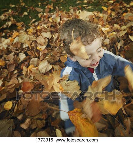 Playing in the autumn leaves View Large Photo Image Stock Photography - Playing in the autumn leaves. Fotosearch