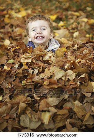 Stock Photograph - Playing with the autumn leaves. Fotosearch