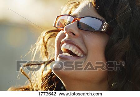 Stock Image - Portrait of attractive woman wearing trendy sunglasses. Fotosearch