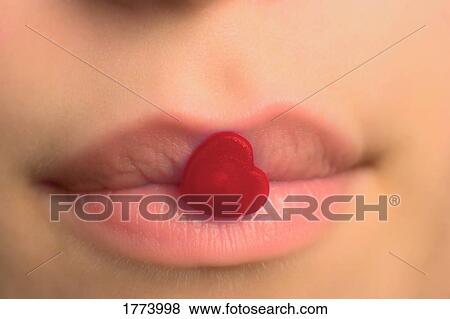 Red heart candy stuck to closed lips View Large Photo Image Stock Photo - Red heart candy stuck to closed lips. Fotosearch