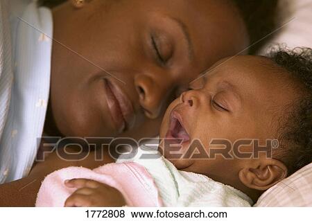 Sleeping mom and yawning baby View Large Photo Image Stock Photo - Sleeping mom and yawning baby. Fotosearch