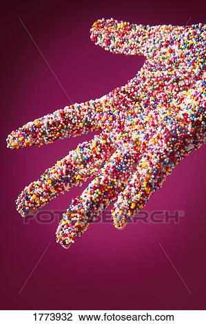 Stock Image - Sprinkle covered hand. Fotosearch